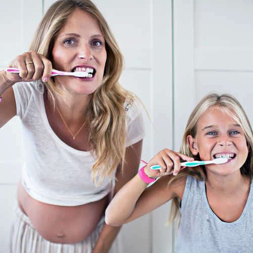 Una mujer embarazada y su hija cepillándose los dientes en Miami.