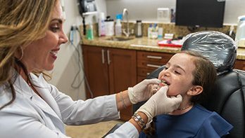 Una niña visita a un dentista general para un chequeo dental.