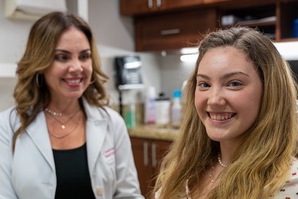 Descripción: una joven sonríe con un dentista en nuestra práctica dental.