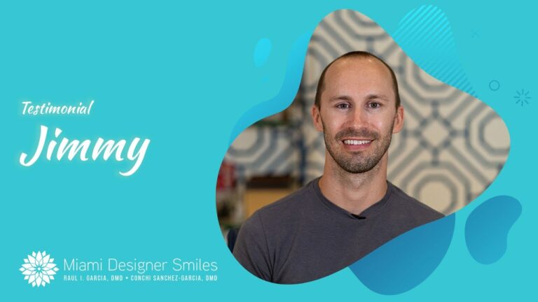 Jimmy is smiling in front of a blue background after undergoing tooth whitening treatment.
