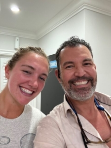 Two people smiling for a selfie indoors.