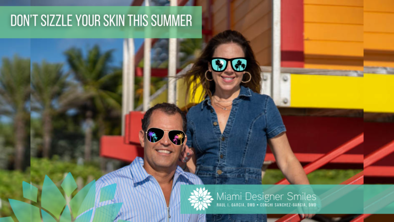 A man and woman wearing sunglasses smile outdoors near a lifeguard tower. Text reads, “Don’t Sizzle Your Skin This Summer – Avoid Sunspots” with a logo for Miami Designer Smiles at the bottom.
