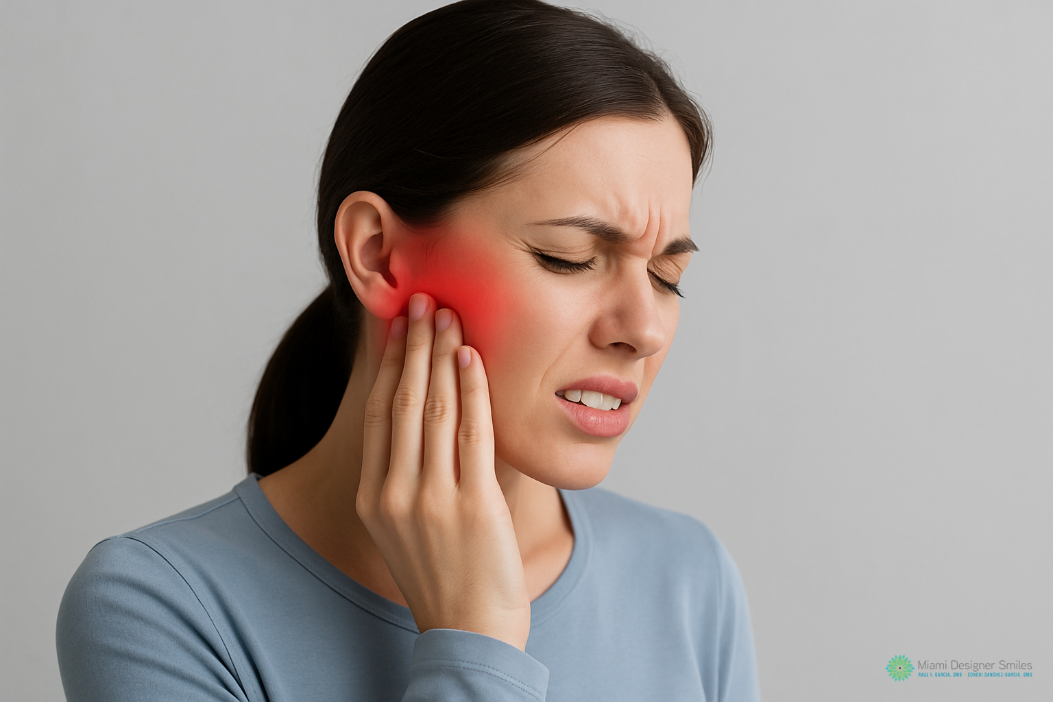 Woman holding her jaw and ear with a pained expression, red highlight around her ear indicating possible ear or jaw pain—consider exploring TMJ treatment options for relief.
